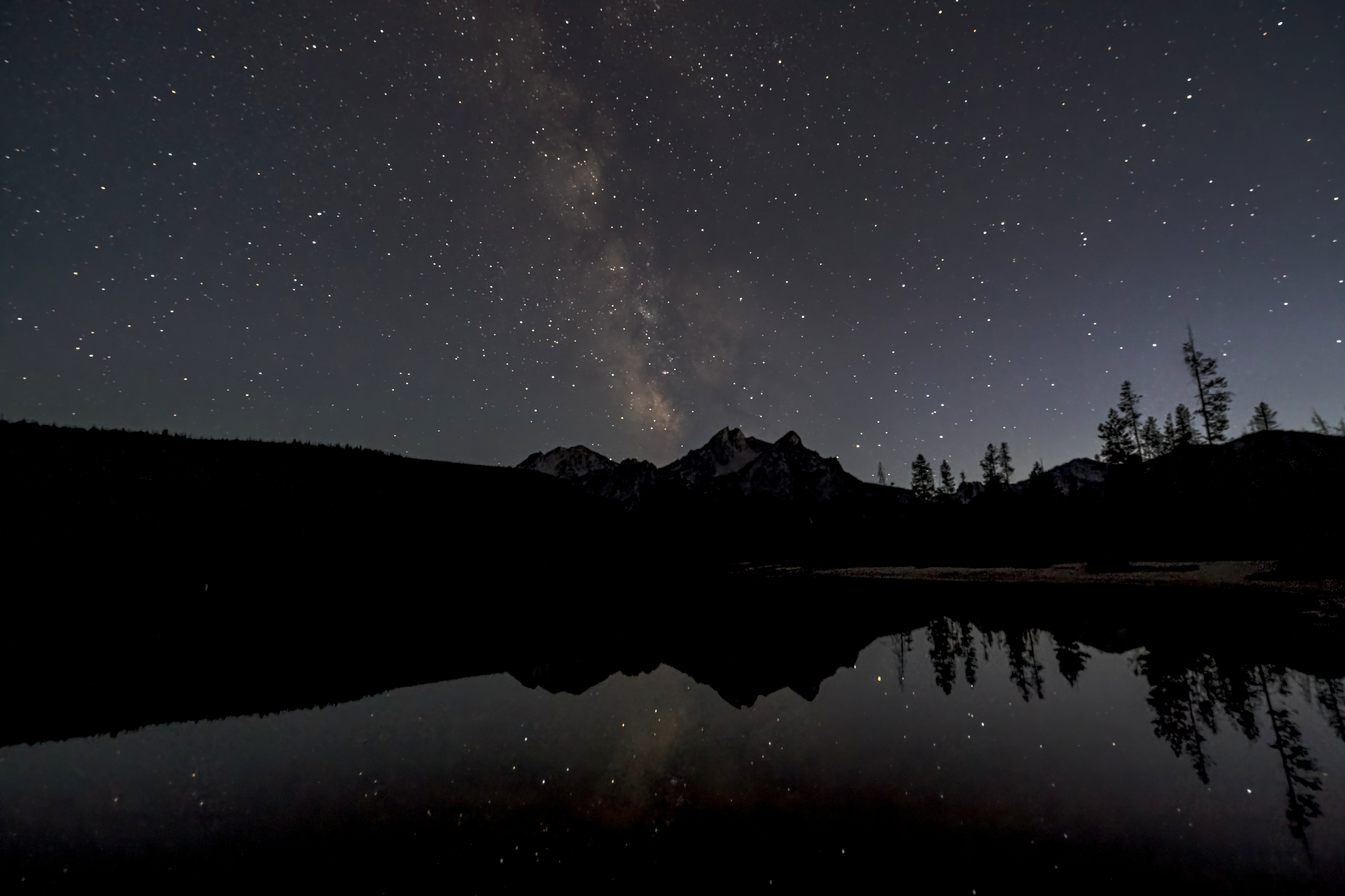 Milky Way reflected over mountain lake